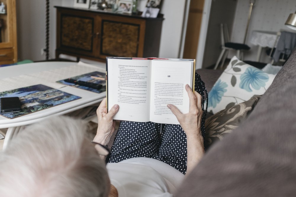 Man läser bok i soffan