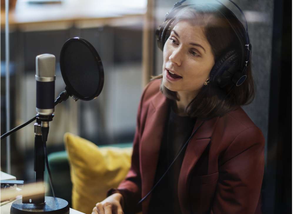 Kvinna som talar i mikrofon i en studio 