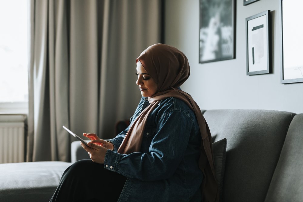 Woman sitting in a sofa holding an IPad 
