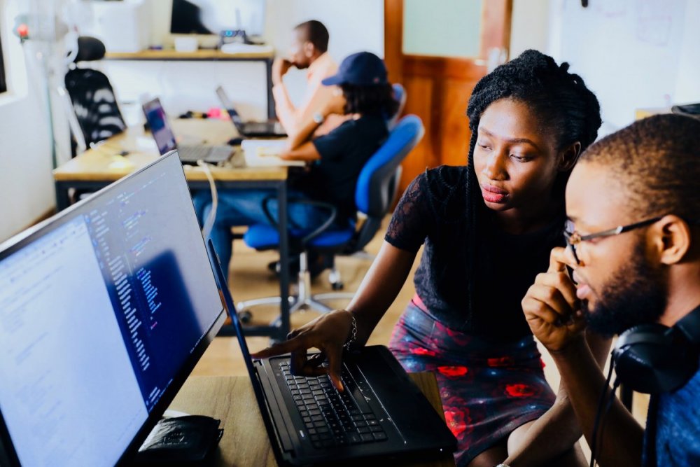 A man and a woman are looking at a computer screen