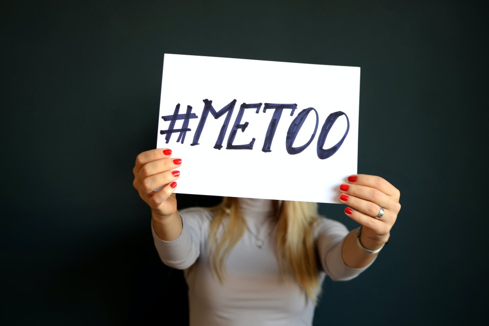 Kvinna som håller upp en skylt med texten "#metoo".