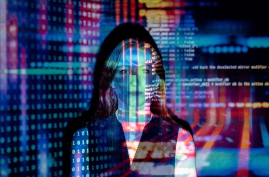 En kvinna står framför en projektion av data på en skärm