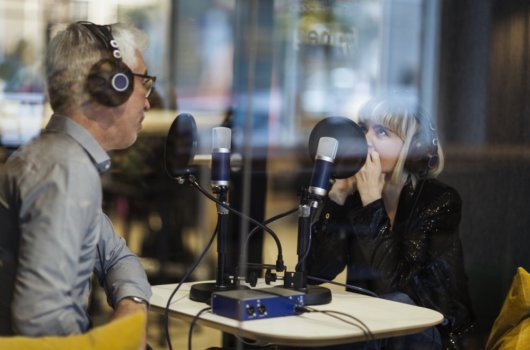 Två personer spelar in podd i en poddstudio