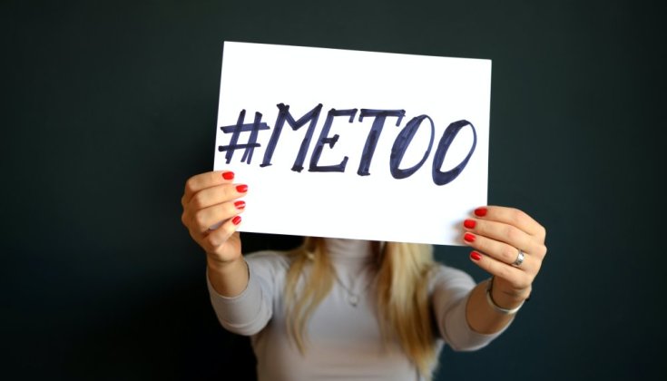 Kvinna som håller upp en skylt med texten "#metoo".